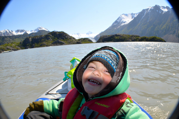 A cheesy picture of Chase as a toddler sitting in the front of a kayak on Grewingk Glacier Lake. 