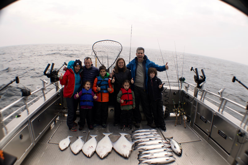 A family of all ages displaying all the Halibut & Salmon they caught on their private fishing charter. 