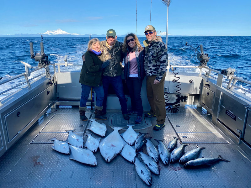 A family displaying all the Halibut & Salmon they caught on a private fishing charter. 
